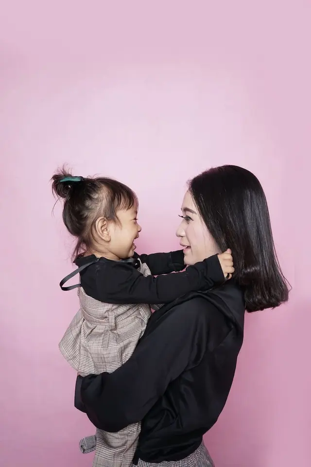 Woman and child in front of pink background